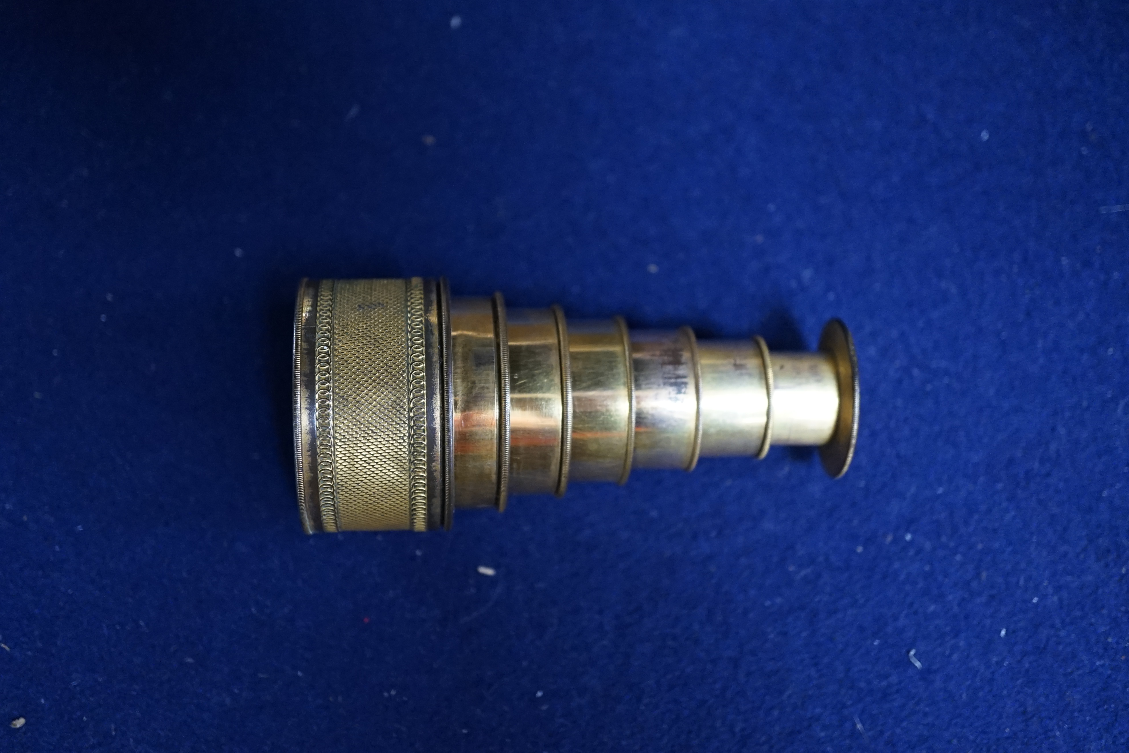 A 19th century gilt brass six drawer monocular telescope by Dollond, London, 10cm fully extended. Condition - fair, some wear to gilt finish.